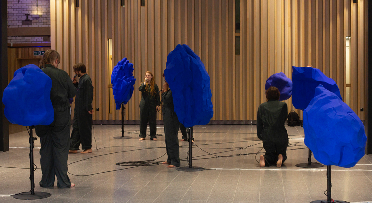 Musicians performing with colourful sculptures